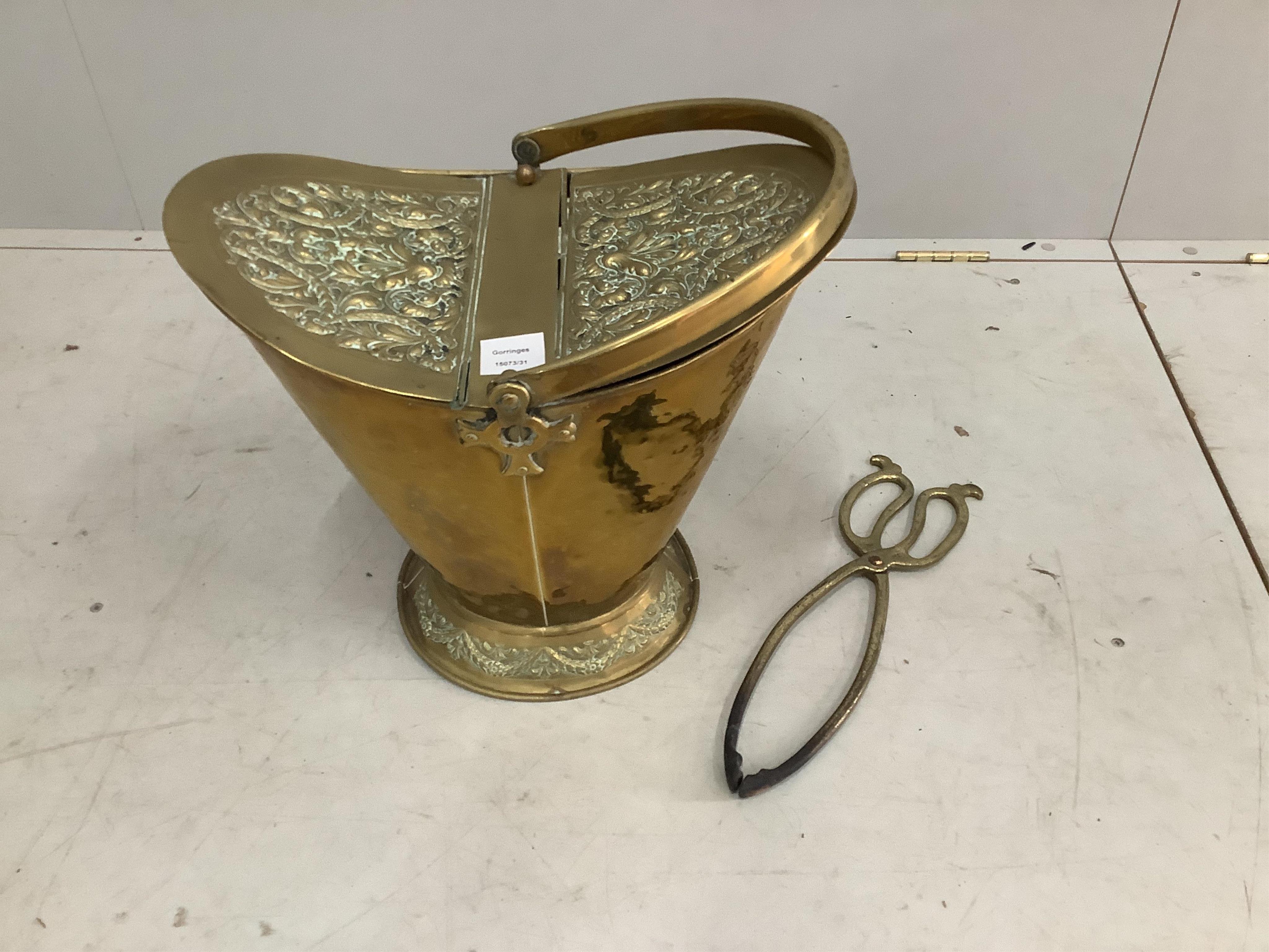 A late Victorian embossed brass coal scuttle, height 43cm, and a pair of tongs. Condition - fair